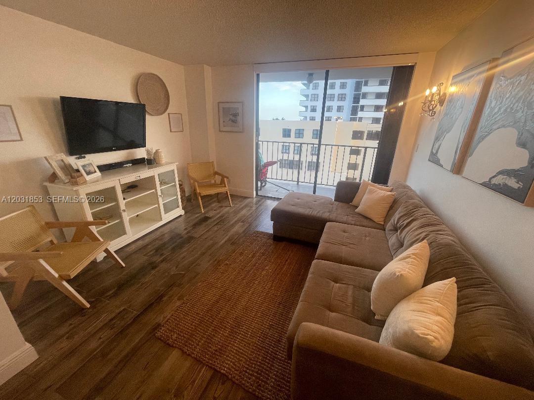 A living room features a sectional sofa, a white media console, and a balcony view — 2625 Collins Ave # 502, Miami Beach FL 33140, MIAMI BEACH, FL