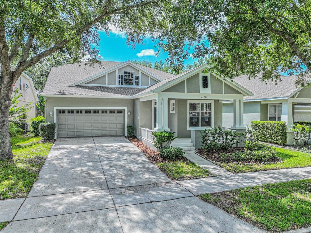 A single-story house with a gray exterior, a two-car garage, and a front porch — 13936 EDEN ISLE BOULEVARD, WINDERMERE, FL
