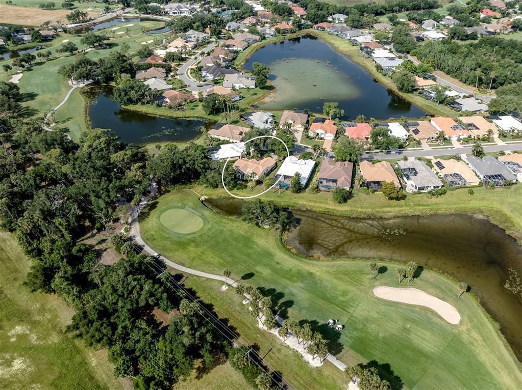 An aerial view shows a residential house circled in a neighborhood bordering a golf course — 417 WELLINGTON COURT, VENICE, FL