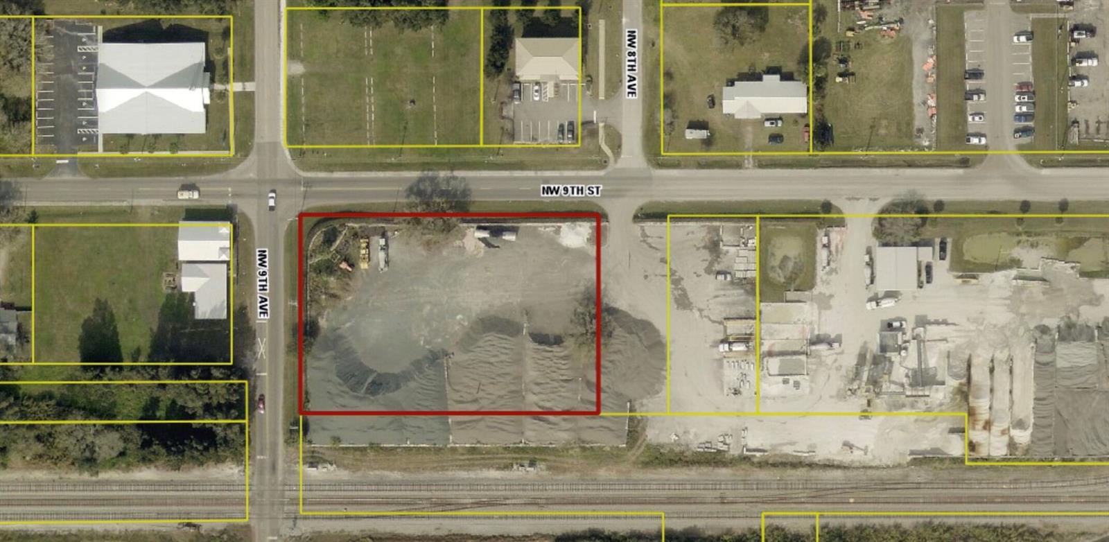 This aerial map shows a vacant, gravel-covered lot outlined in red near a railroad track — 805 NW 9th Street, Okeechobee FL 34972, OKEECHOBEE, FL