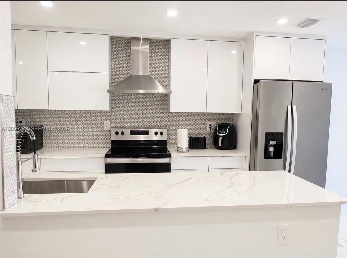 A modern kitchen features white cabinets, stainless steel appliances, and a marble-patterned island countertop — 8224 NW 9th Ct # 3, Plantation FL 33324, PLANTATION, FL