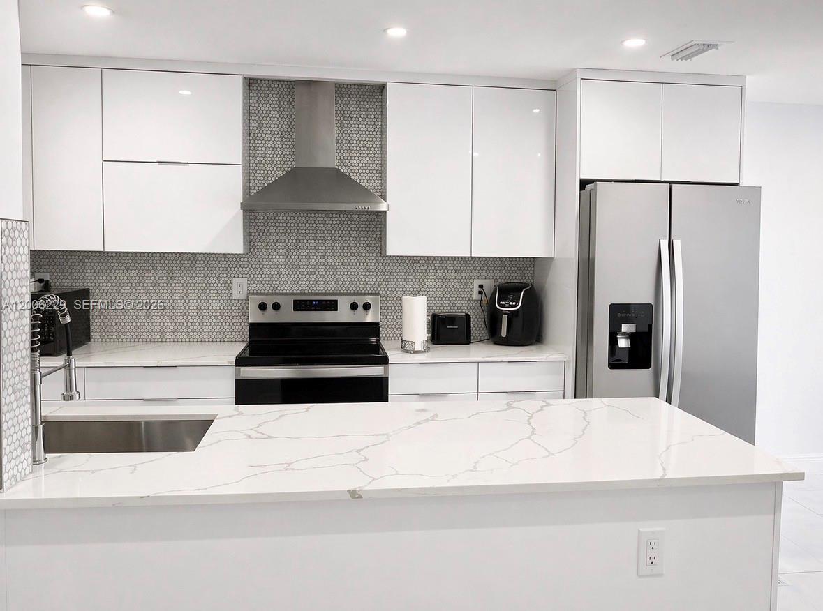 A modern kitchen features white cabinets, a marble-patterned island, and stainless steel appliances — 8224 NW 9th Ct # 3, Plantation FL 33324, PLANTATION, FL