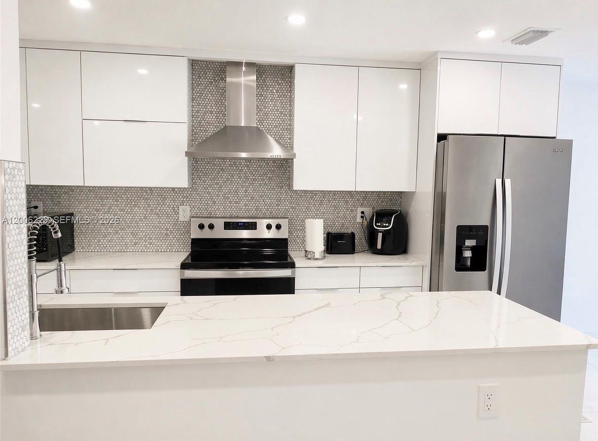 A modern kitchen features white cabinets, a marble-look countertop, stainless steel appliances, and a tiled backsplash — 8224 NW 9th Ct # 3, Plantation FL 33324, PLANTATION, FL