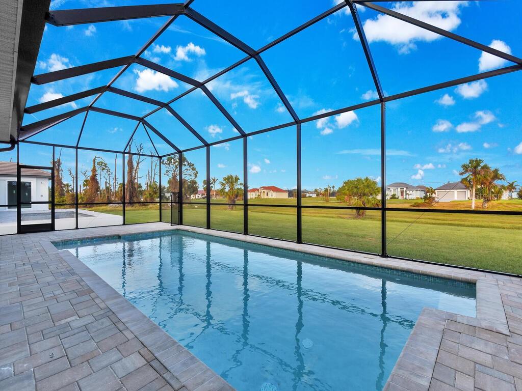 A covered patio with a pool, outdoor furniture, and a screened enclosure overlooking a yard — 193 ROTONDA BOULEVARD S, ROTONDA WEST, FL