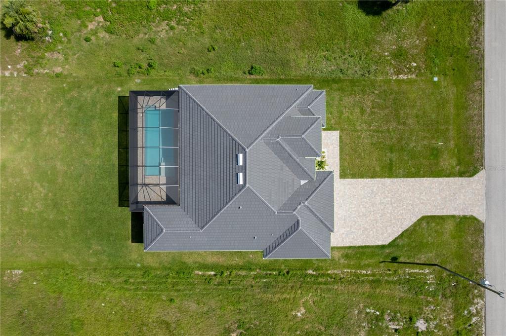 An aerial view shows a house with a tiled roof, a screened-in pool, and a driveway — 193 ROTONDA BOULEVARD S, ROTONDA WEST, FL