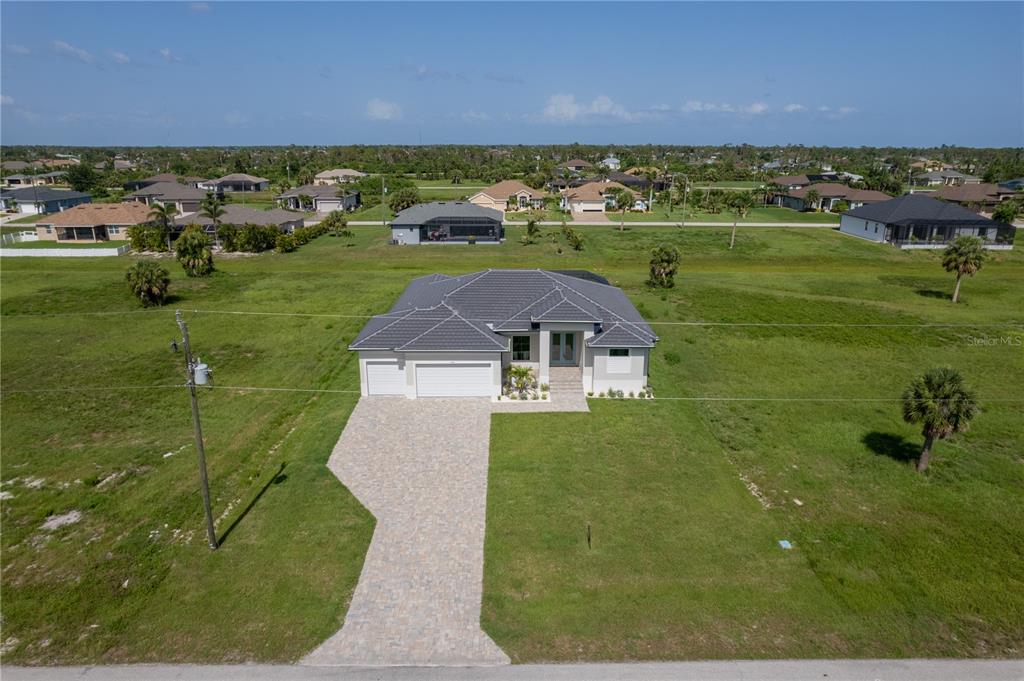 An aerial view shows a single-story house with a gray tile roof and paved driveway — 193 ROTONDA BOULEVARD S, ROTONDA WEST, FL