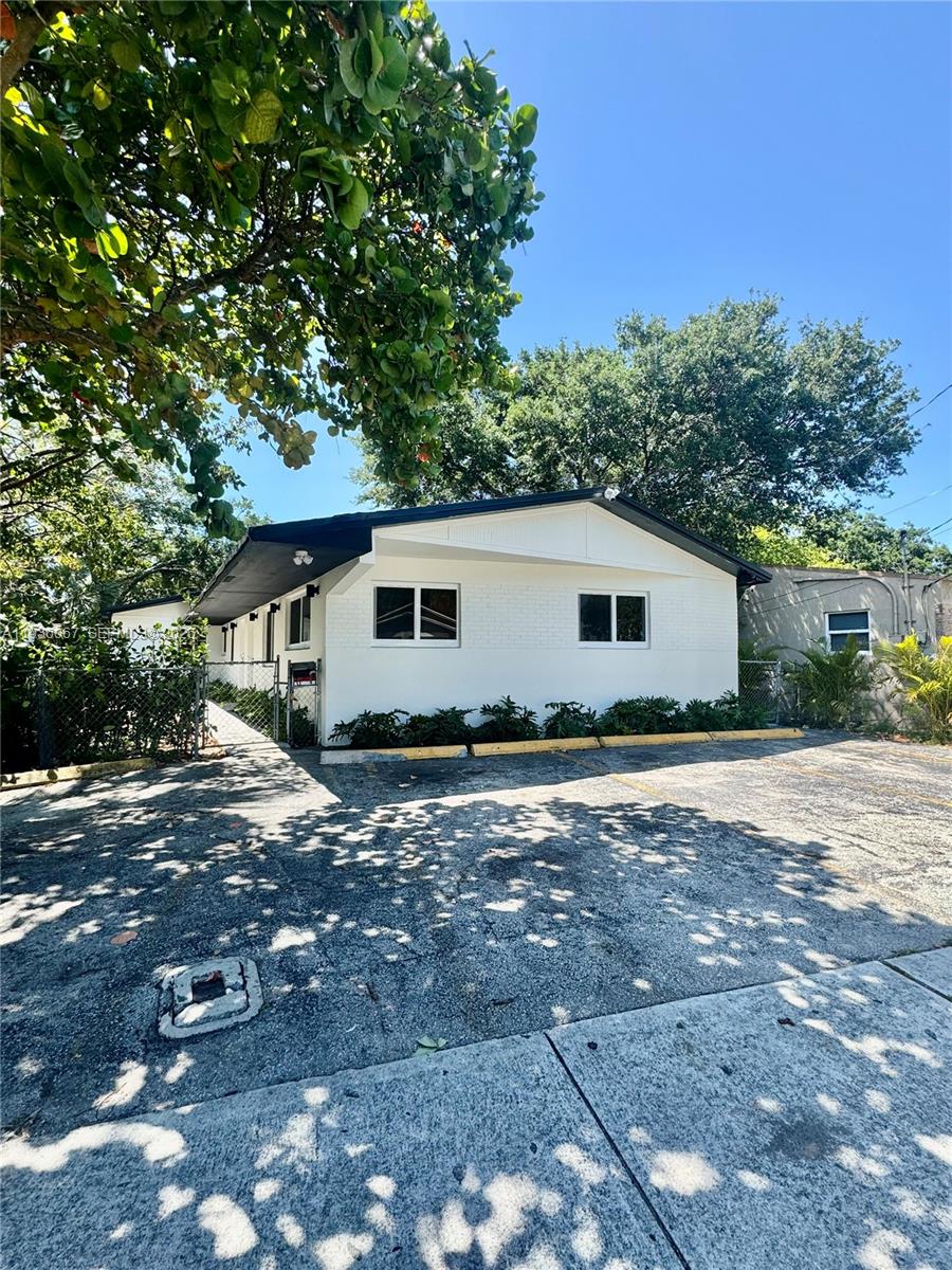 A white, single-story building with a dark roof sits behind a paved parking lot — 111 NW 7th Ave, Dania Beach FL 33004, DANIA BEACH, FL