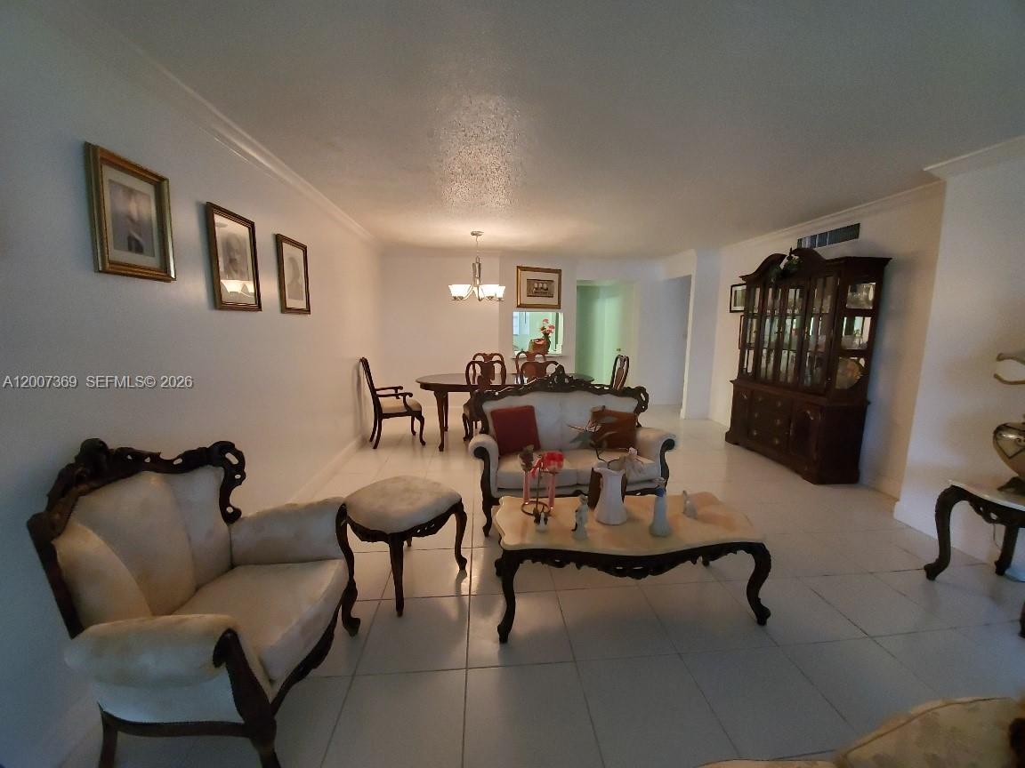 A living and dining area features white tile floors, traditional furniture, and white walls — 1750 NE 191st St # 1, Miami FL 33179, MIAMI, FL