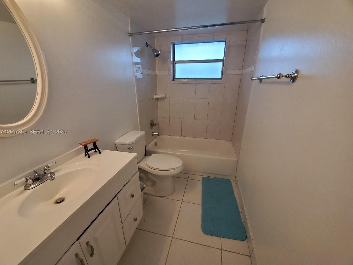 A bathroom features a white vanity, a toilet, and a tiled bathtub shower combination — 1750 NE 191st St # 1, Miami FL 33179, MIAMI, FL