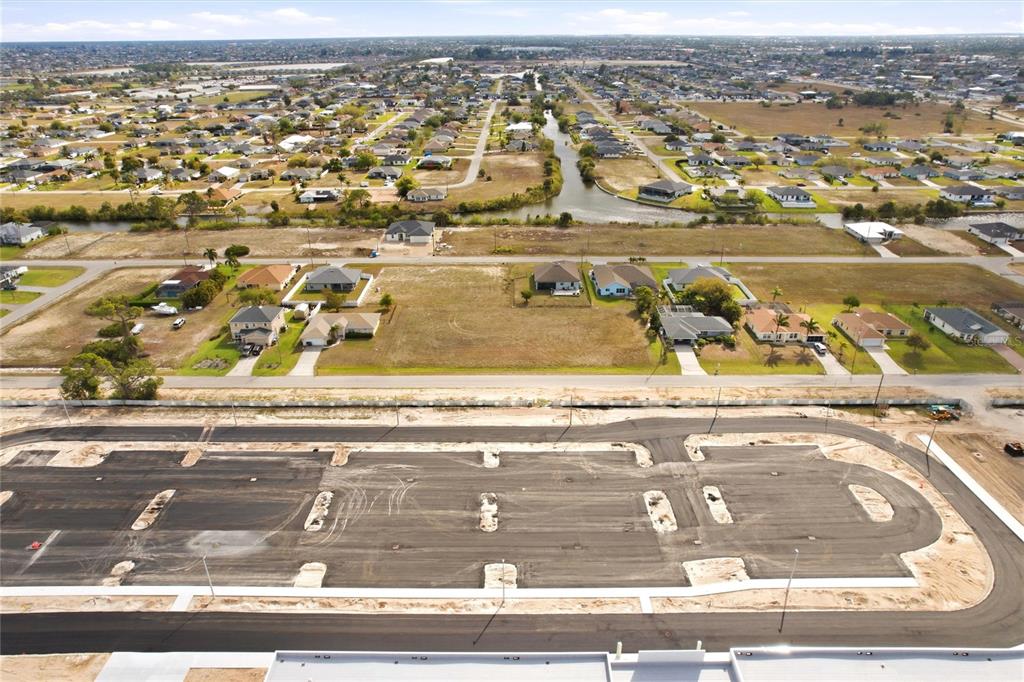 An aerial view shows a newly paved cul-de-sac street in front of residential lots — 217 NW 20TH AVENUE, CAPE CORAL, FL