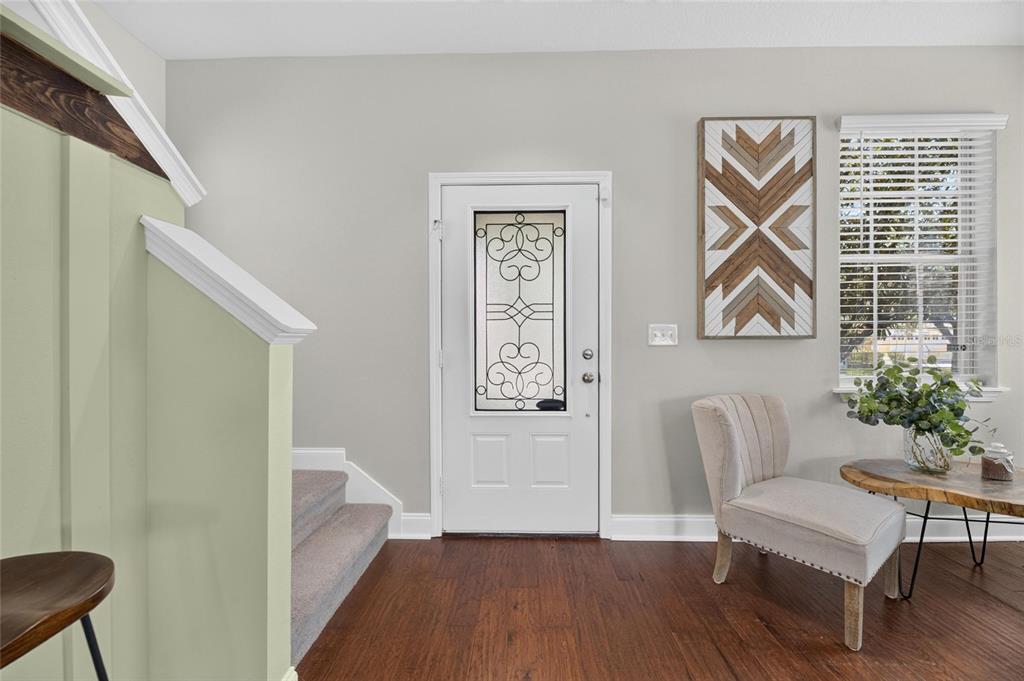 An entryway features a white front door, a staircase with light green walls, and a chair — 8635 TURNSTONE SHORE LANE, RIVERVIEW, FL