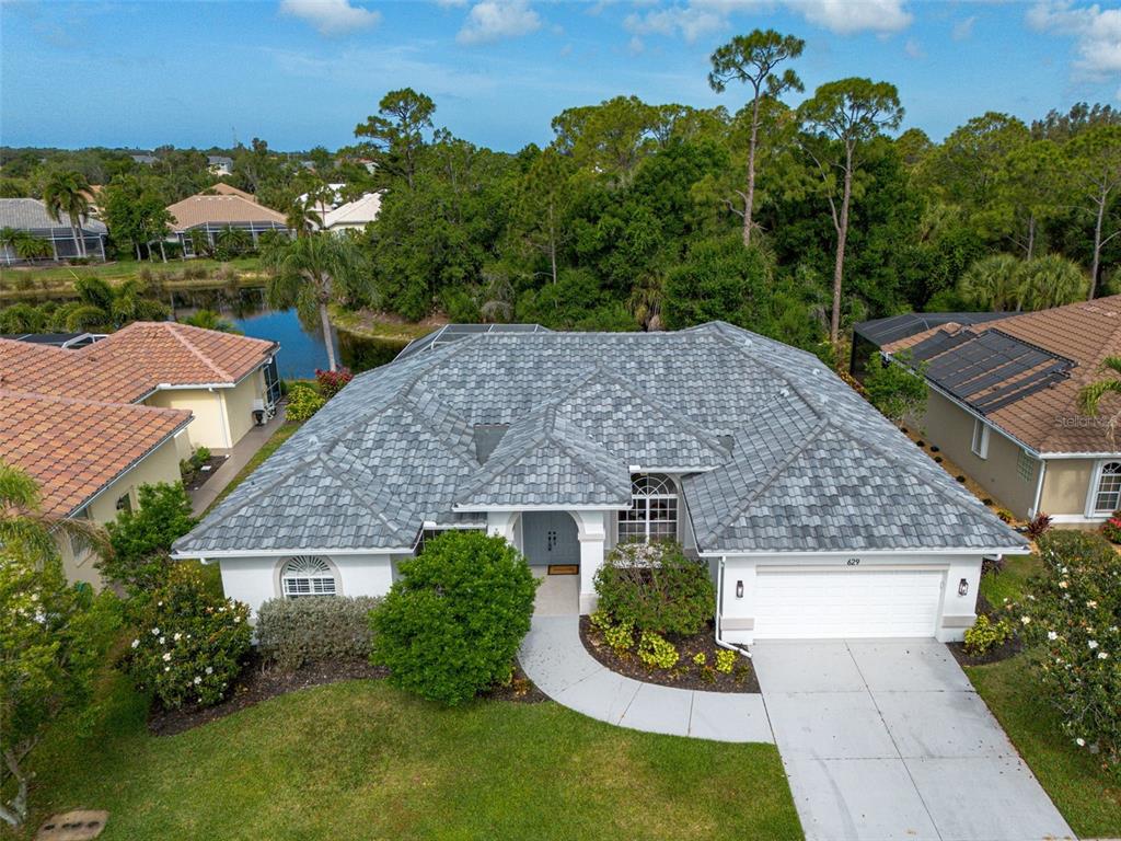 An aerial view of a single-story house with a gray tile roof and white exterior — 629 SAWGRASS BRIDGE ROAD, VENICE, FL