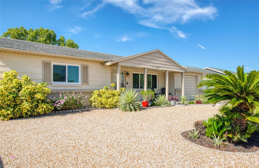 A single-story house with beige siding, a gravel front yard, and a covered entryway — 6014 3RD AVENUE, NEW PORT RICHEY, FL