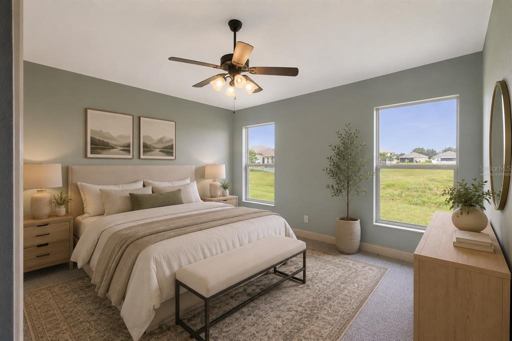 A bedroom with sage green walls, a king bed, two windows, and a ceiling fan — 1761 BONITA BLUFF COURT, RUSKIN, FL