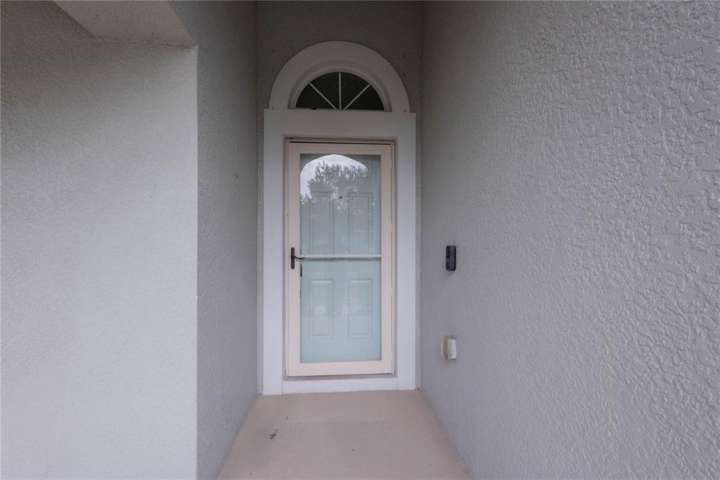 A front entryway features a glass storm door with an arched transom window above — 1761 BONITA BLUFF COURT, RUSKIN, FL