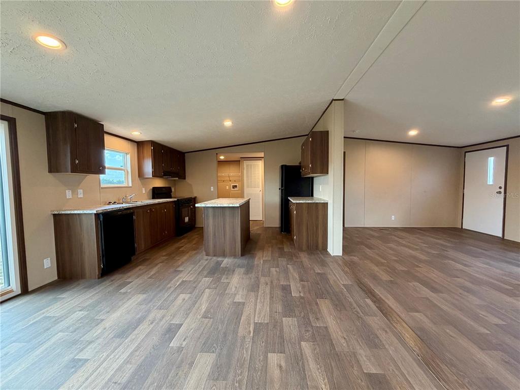 A kitchen with dark wood cabinets, a center island, and wood-look flooring — 4507 BIG TANK ROAD, LAKE WALES, FL