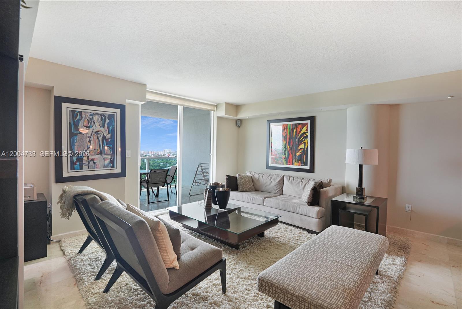 A living room features a sofa, two chairs, a glass coffee table, and a balcony — 2101 Brickell Ave # 1812, Miami FL 33129, MIAMI, FL