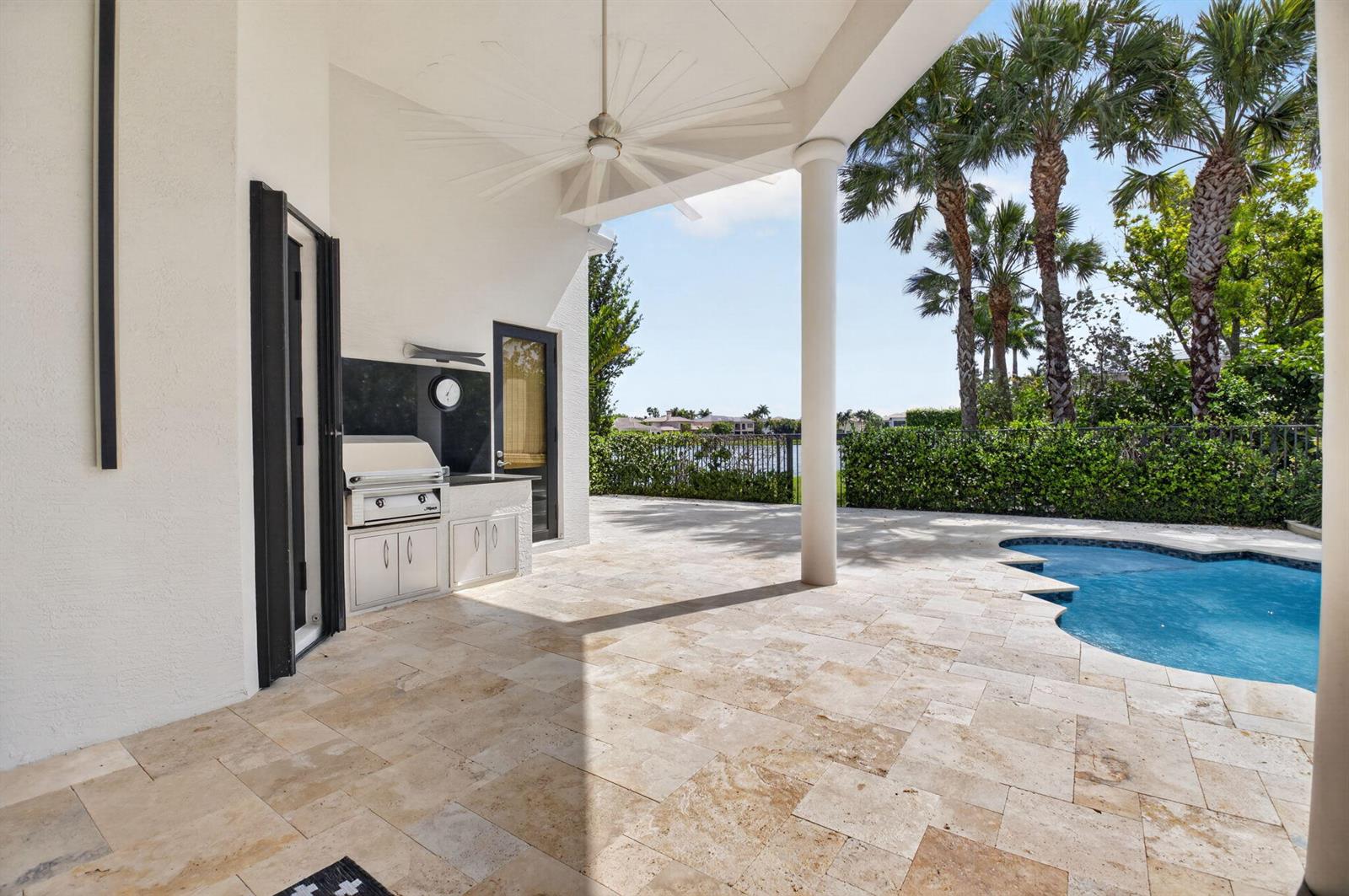 A covered patio features a built-in grill, stone tile flooring, and a swimming pool — 17921 Villa Club Way, Boca Raton FL 33496, BOCA RATON, FL