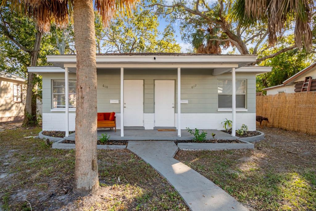 A single-story duplex with light green siding, white trim, and a concrete front porch — 610 16TH AVENUE S, ST PETERSBURG, FL