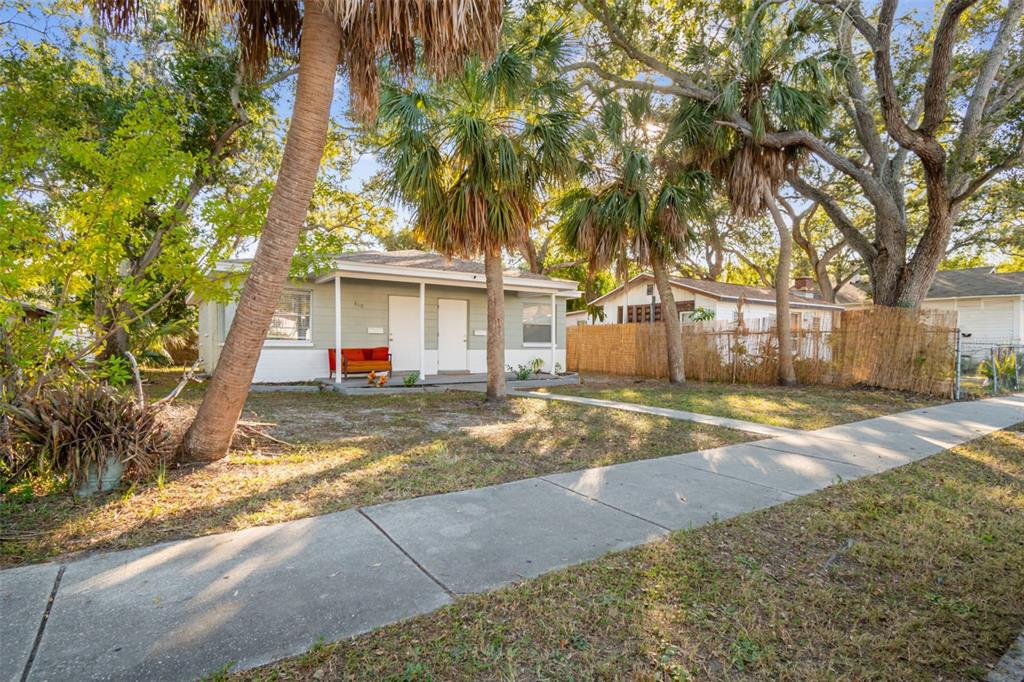A single-story house with a light green exterior and a front porch sits behind palm trees — 610 16TH AVENUE S, ST PETERSBURG, FL