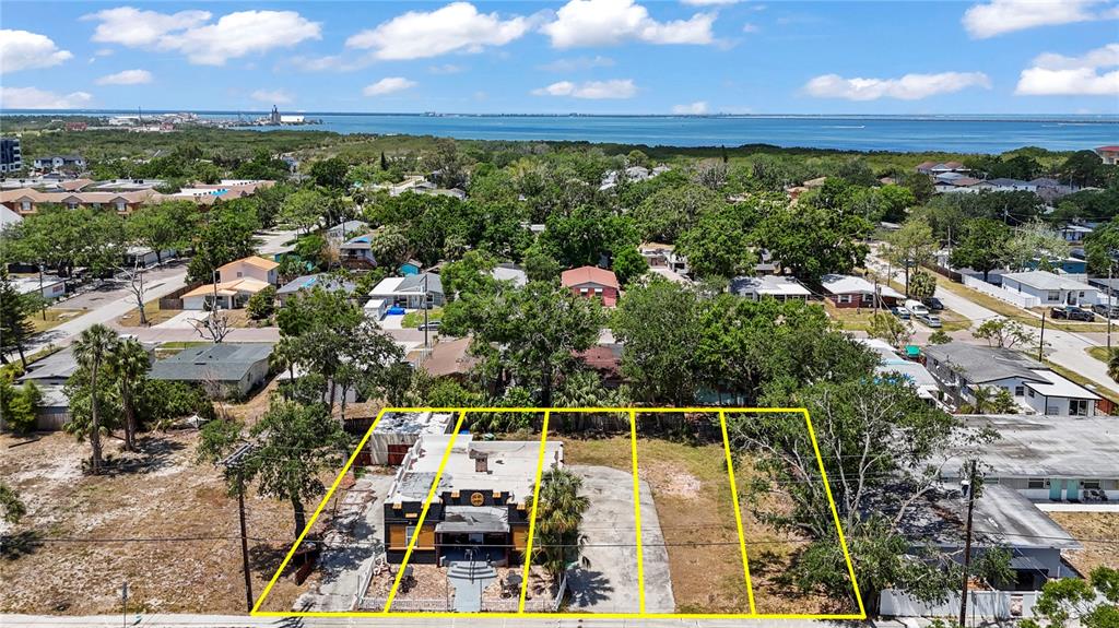 An aerial view shows a commercial building and adjacent vacant lots near the water — 6719 S WEST SHORE BOULEVARD, TAMPA, FL