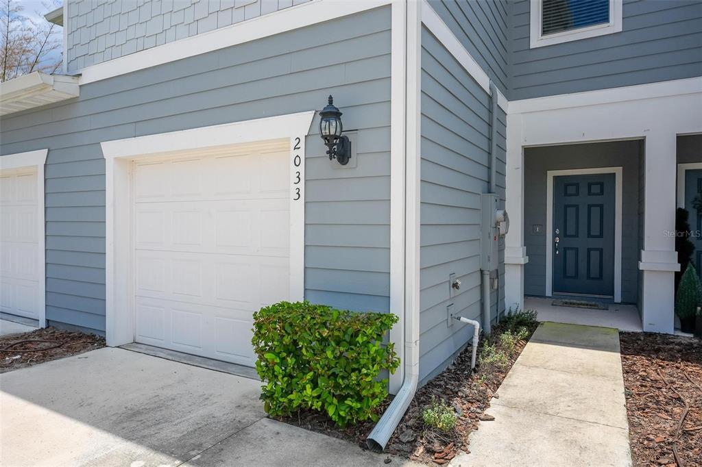 The exterior of a house features blue siding, a white garage door, and a front entrance — 2033 CANNY COVE, WINTER PARK, FL