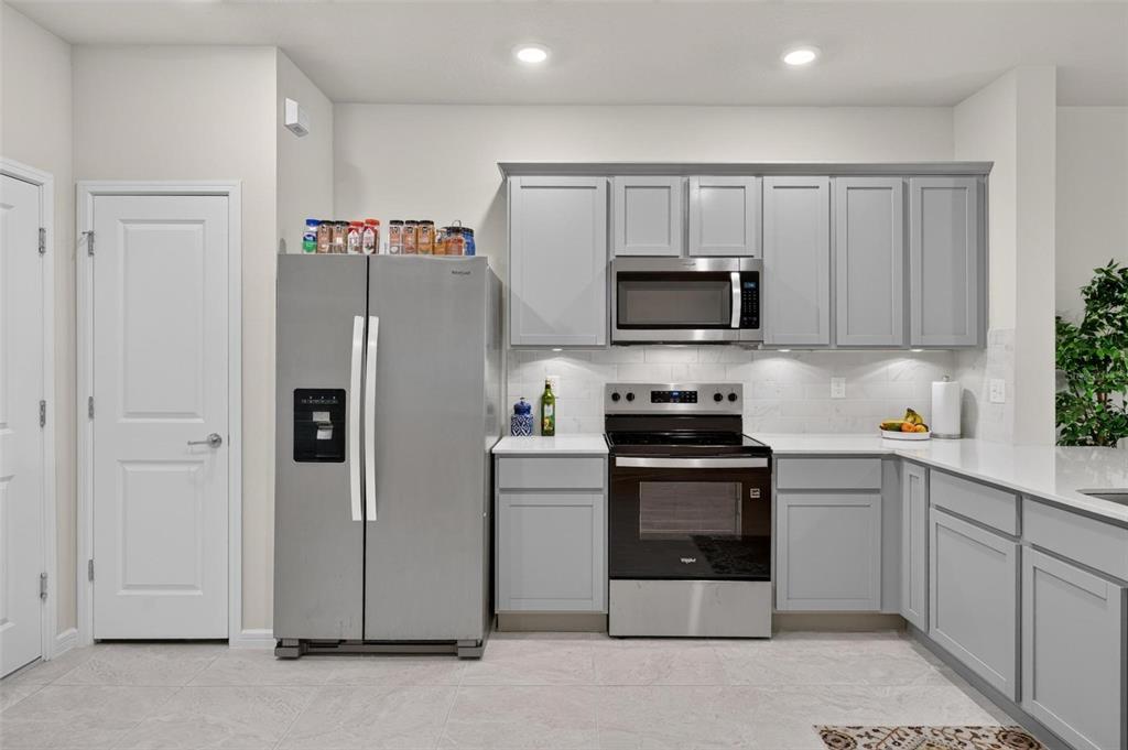 A kitchen features gray cabinets, stainless steel appliances, and white countertops — 2033 CANNY COVE, WINTER PARK, FL