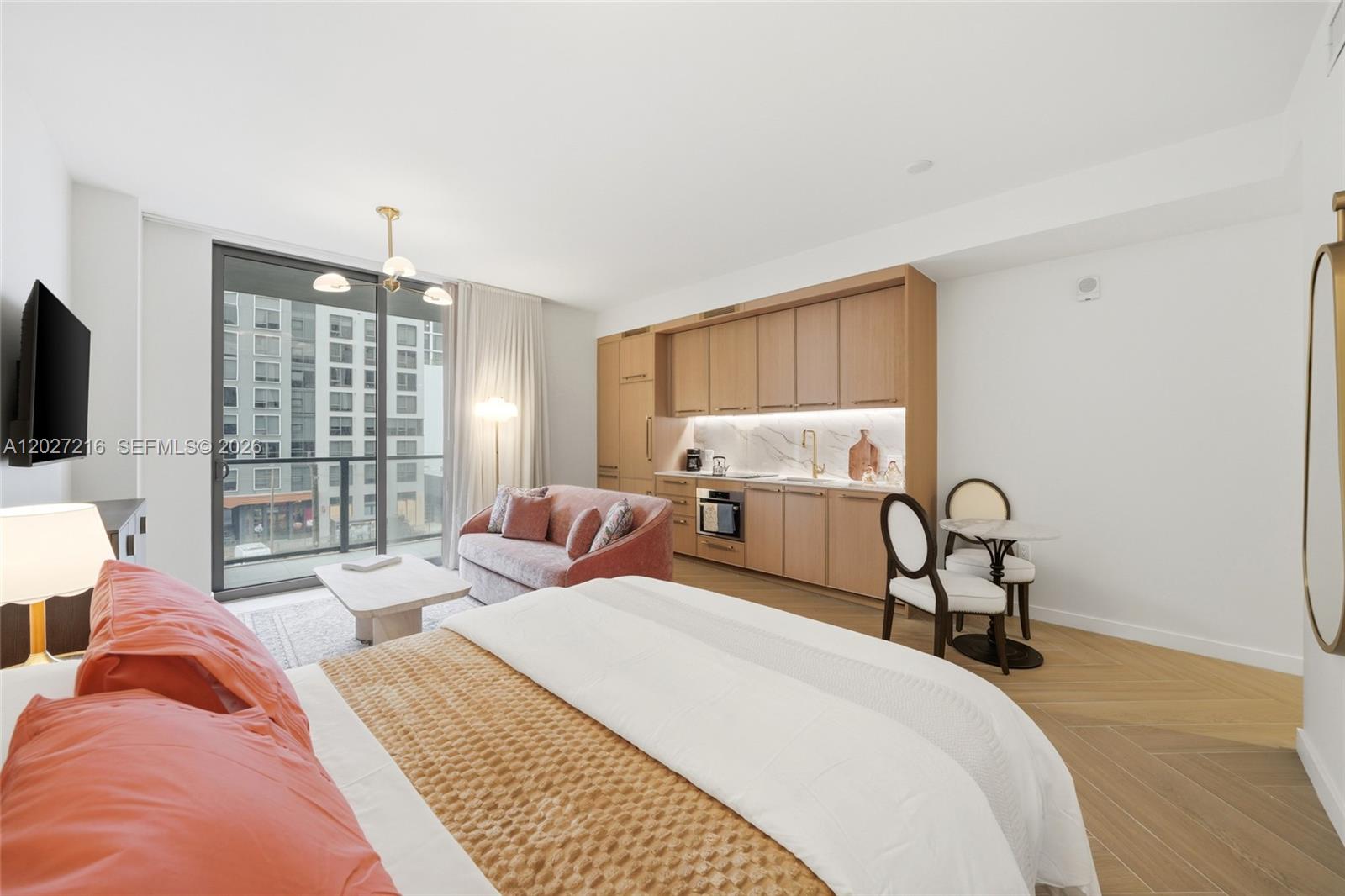 A studio apartment features a kitchenette, a bed, a sofa, and a balcony with city views — 2700 NW 2nd Ave # 345, Miami FL 33127, MIAMI, FL