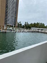 A view of a marina with boats docked next to a tall residential building — 770 NE 69th St # 1E, Miami FL 33138, MIAMI, FL