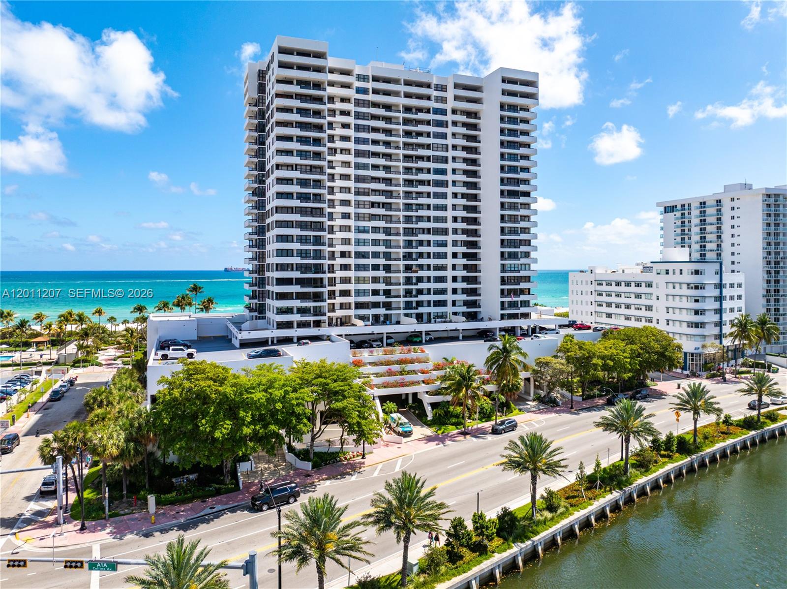 An aerial view shows a tall white residential building situated between a road and the ocean — 2555 Collins Ave # 2014, Miami Beach FL 33140, MIAMI BEACH, FL
