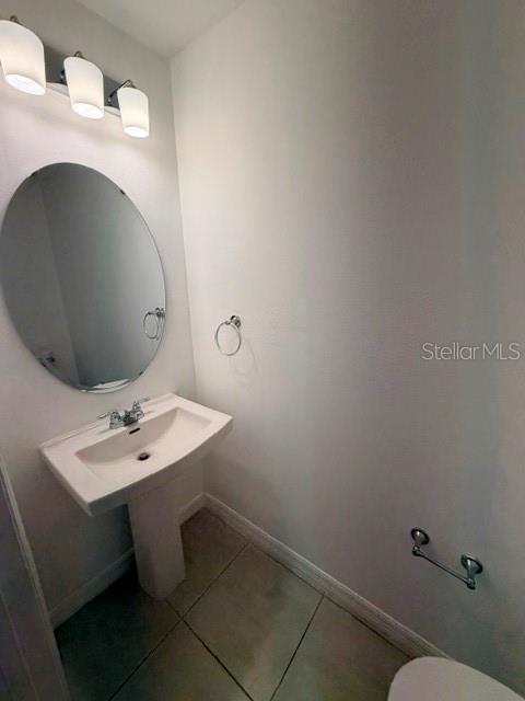 A half bathroom features a pedestal sink, an oval mirror, and a three-light vanity fixture — 3188 SKYLINE LOOP, KISSIMMEE, FL