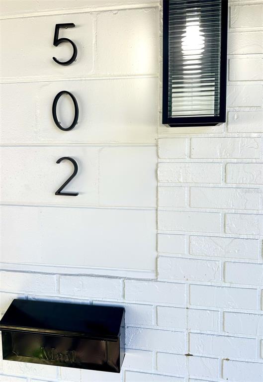 A black mailbox and house numbers 502 are mounted on a white painted brick wall — 502 E KNOLLWOOD STREET, TAMPA, FL