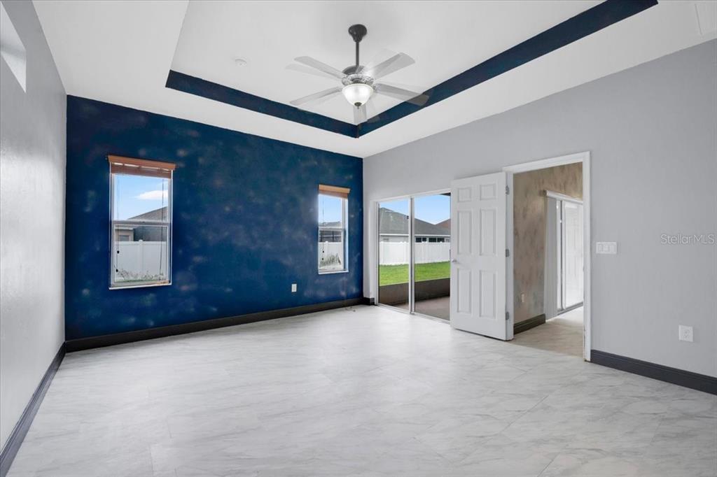 A room with white tile floors, a dark blue accent wall, and a tray ceiling — 2850 SHELDON STREET, LAKELAND, FL