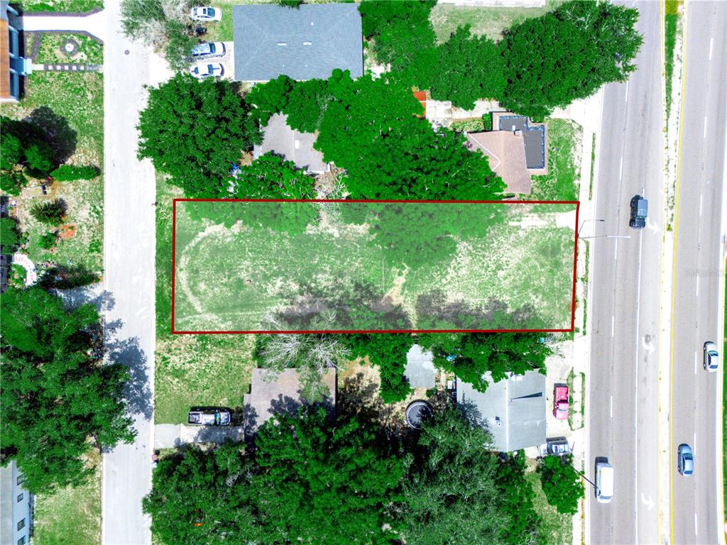 An aerial view shows a rectangular vacant lot outlined in red between two residential properties — 60 E STREET, LAKE WALES, FL