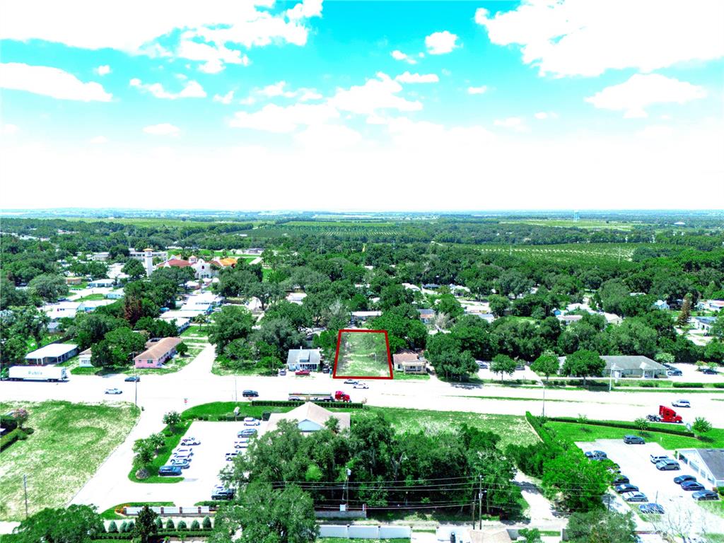 An aerial view shows a vacant rectangular lot outlined in red within a residential neighborhood — 60 E STREET, LAKE WALES, FL