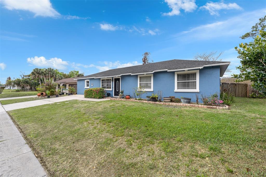 A blue single-story house with a gray shingled roof and a front lawn — 8509 LYONIA DRIVE, ORLANDO, FL