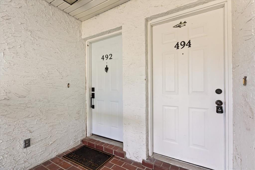 Two white apartment doors labeled 492 and 494 are set in a textured stucco wall — 494 W PAR STREET, ORLANDO, FL