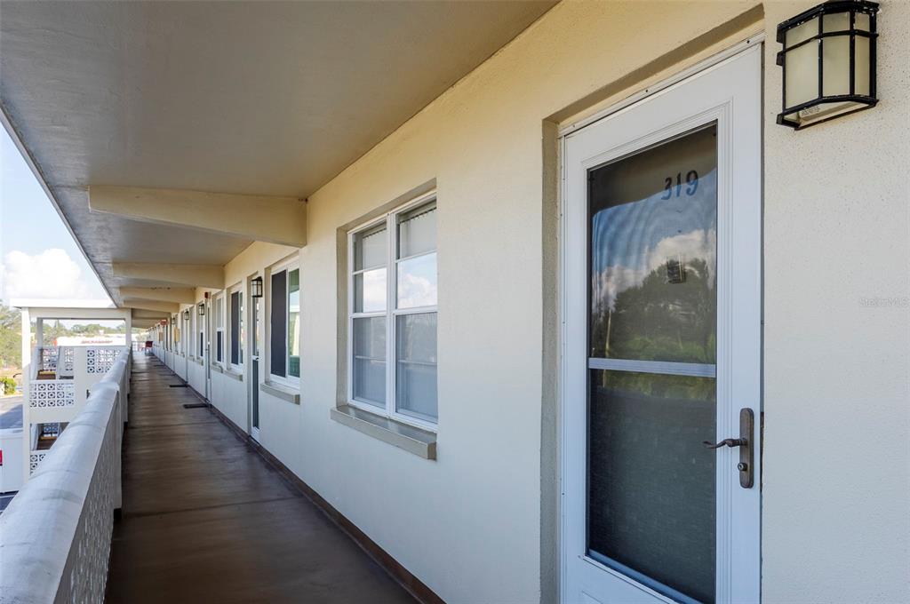 An exterior view of a two-story apartment building with decorative concrete block balcony railings — 8101 11TH STREET N UNIT 319, ST PETERSBURG, FL