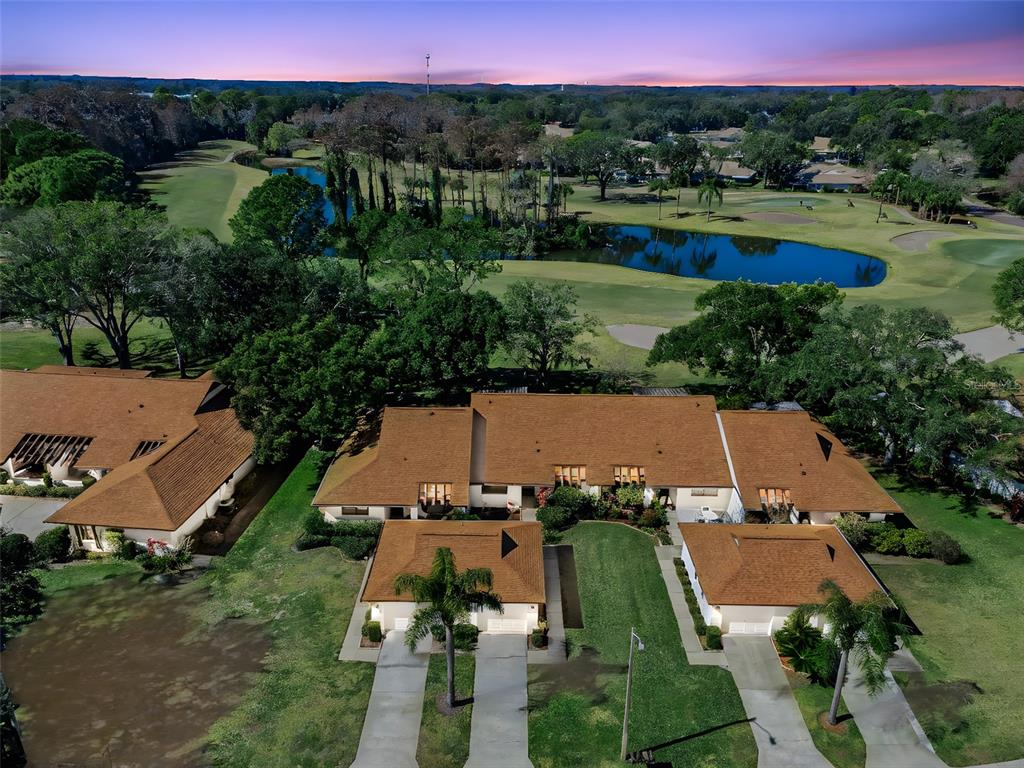An aerial view shows a multi-unit residential building with brown roofs overlooking a golf course — 3351 LORI LANE UNIT 3351, NEW PORT RICHEY, FL