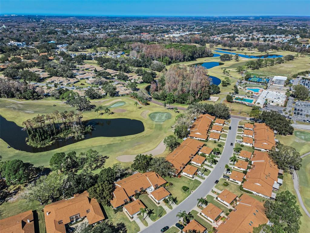 Aerial view of a residential community with townhomes, a golf course, and several ponds — 3351 LORI LANE UNIT 3351, NEW PORT RICHEY, FL