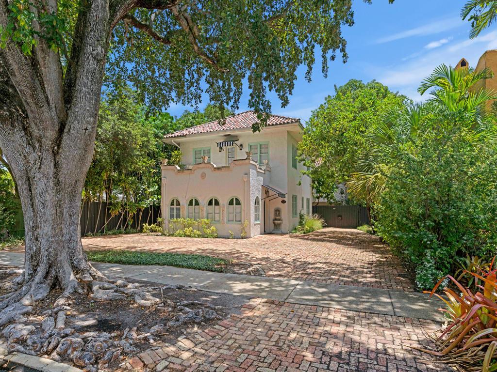 A two-story stucco house with arched windows and a brick driveway sits under large trees — 333 Marlborough Road, West Palm Beach FL 33405, WEST PALM BEACH, FL