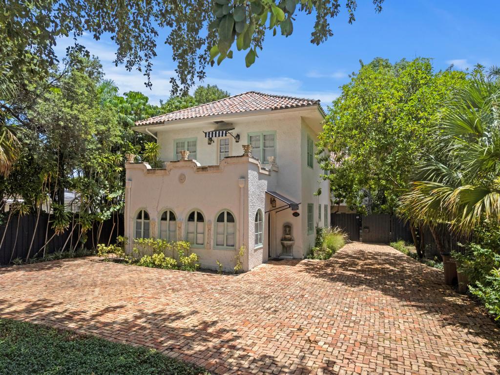 A two-story Mediterranean-style house with a brick driveway and arched windows sits among lush trees — 333 Marlborough Road, West Palm Beach FL 33405, WEST PALM BEACH, FL