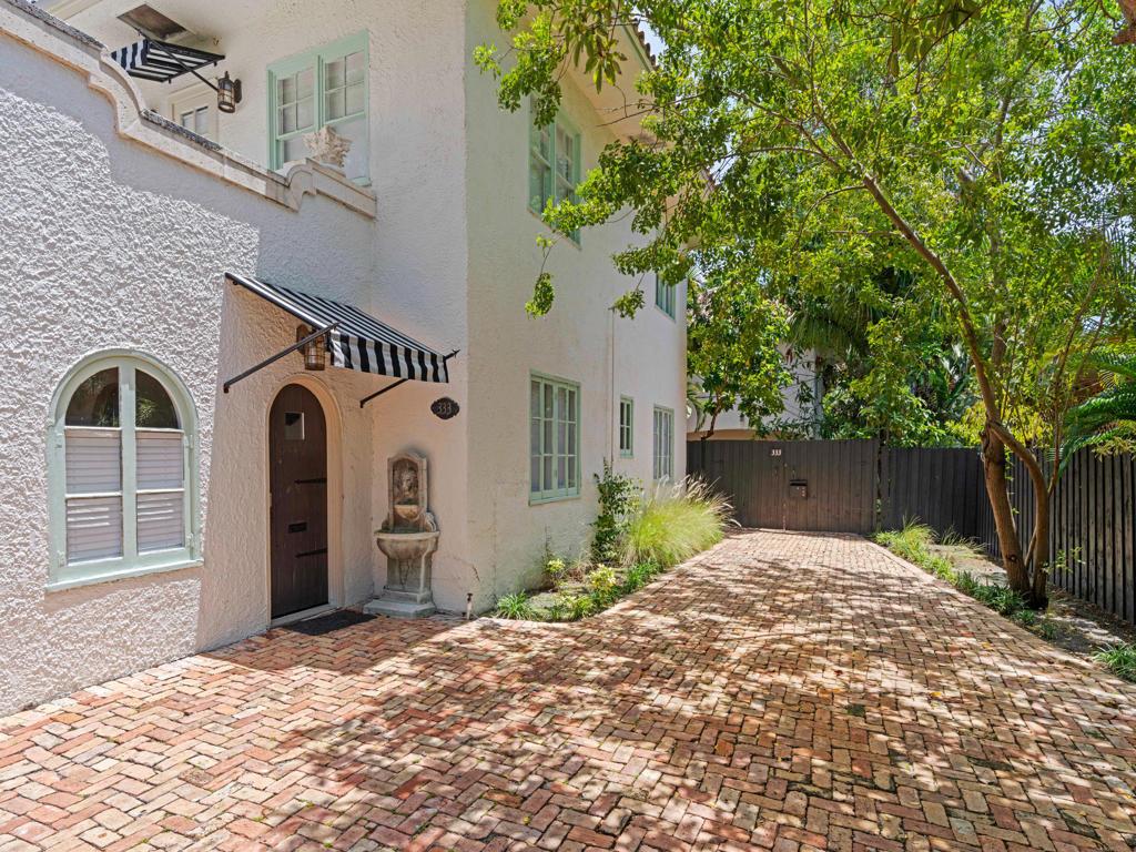 A white stucco house with a brick driveway, arched doorway, and black and white striped awning — 333 Marlborough Road, West Palm Beach FL 33405, WEST PALM BEACH, FL