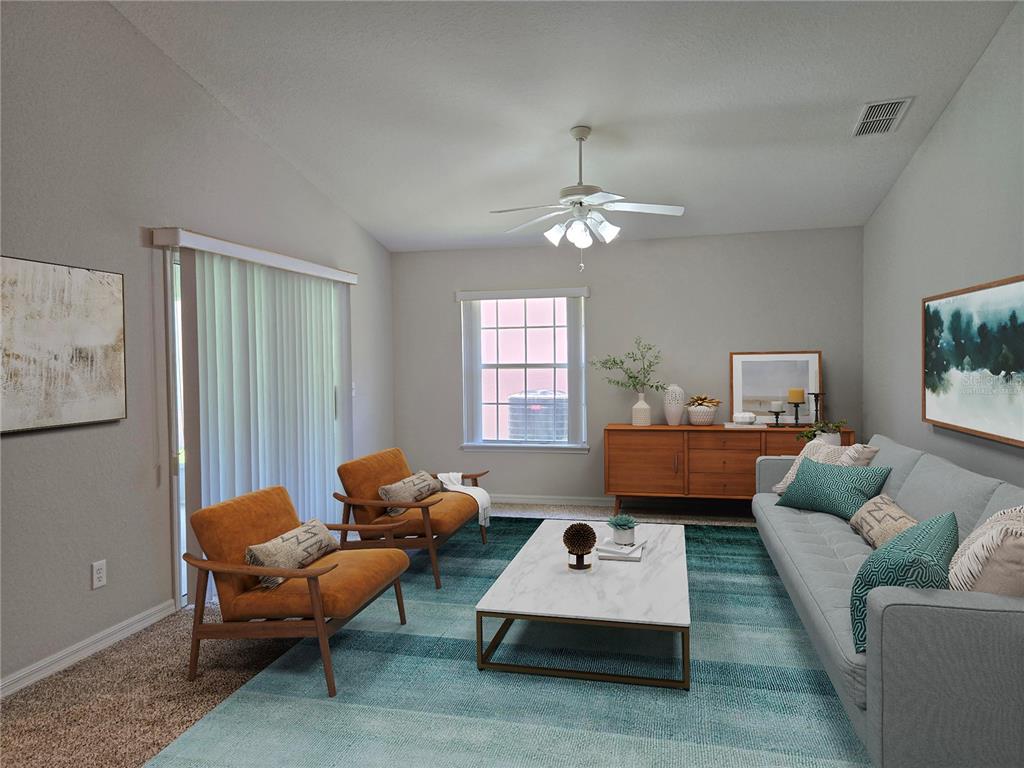 A living room features a light blue sofa, two orange armchairs, and a marble coffee table — 17974 SE 115TH CIRCLE, SUMMERFIELD, FL
