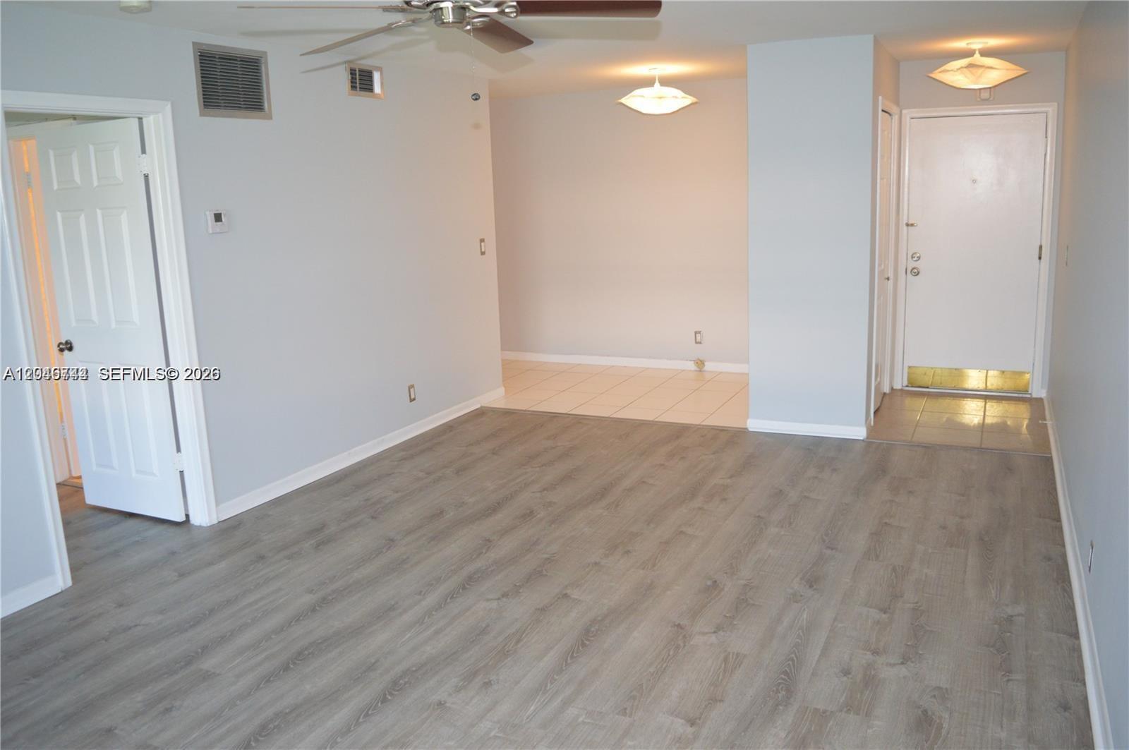 An interior view shows a living area with wood-look flooring and an adjacent tiled space — 9 NE 19th Ct # 204C, Wilton Manors FL 33305, WILTON MANORS, FL