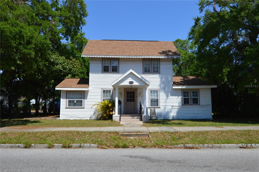 A two-story white house with horizontal siding and a gabled front porch entrance — 811 18TH AVENUE S, ST PETERSBURG, FL