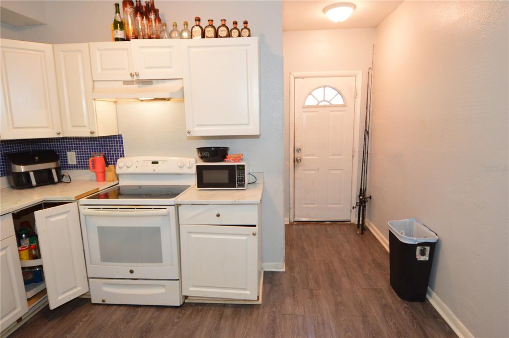 A kitchen with white cabinets, a white stove, a microwave, and a back door — 811 18TH AVENUE S, ST PETERSBURG, FL