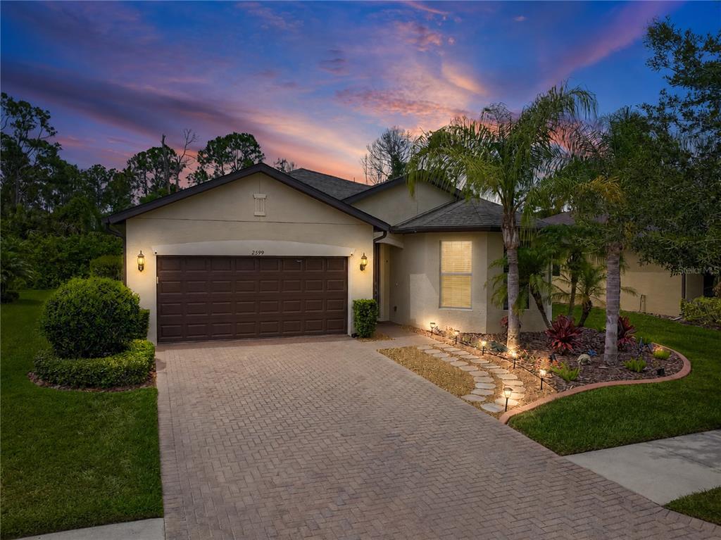 A living room with a large entertainment center, leather sofa, and tile flooring — 2599 SHERMAN OAK DRIVE, NORTH PORT, FL