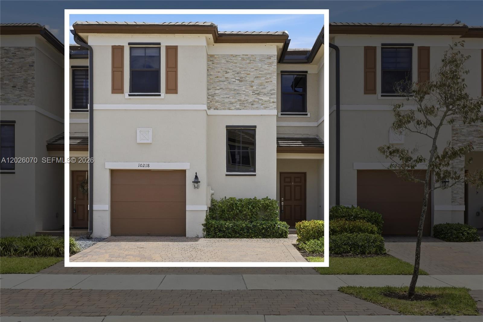 A two-story townhouse exterior features a brown garage door, stone accents, and a paved driveway — 10218 SW 231st Ln, Cutler Bay FL 33190, CUTLER BAY, FL