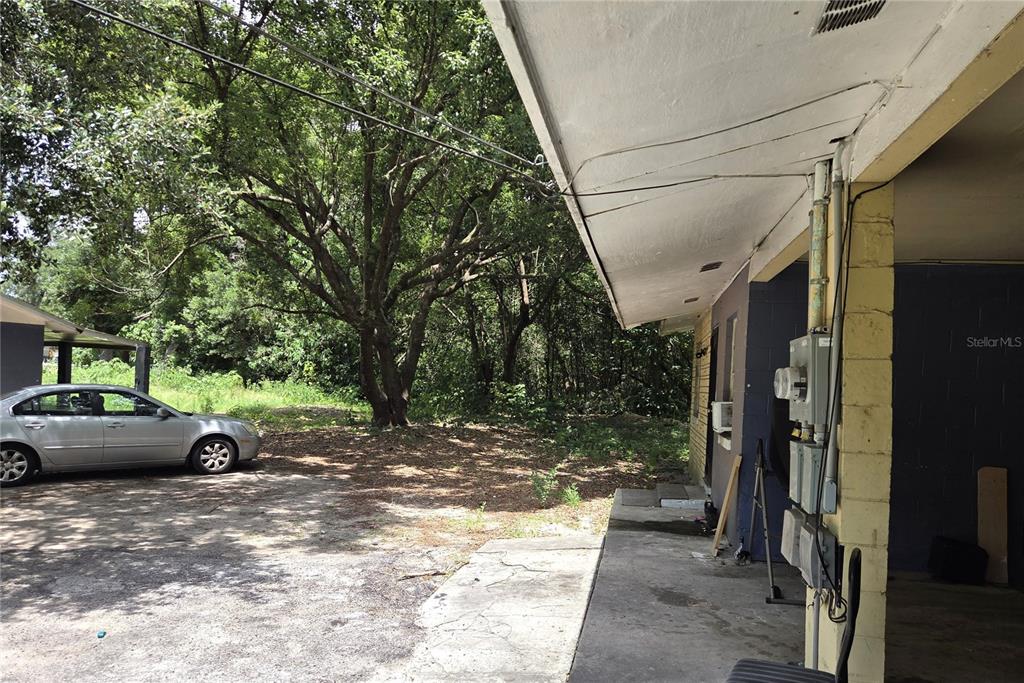 A silver sedan is parked on a dirt and concrete lot beside a building exterior — 521-535 NW 19TH AVENUE, OCALA, FL
